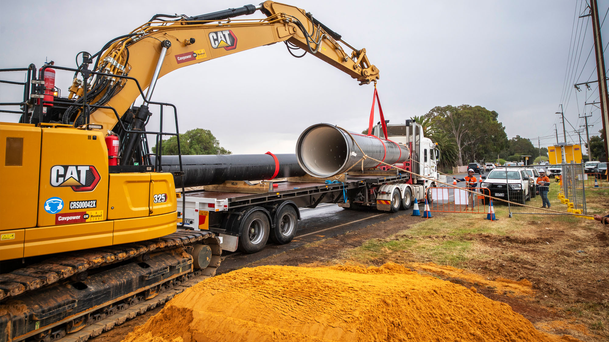 Large water main being delivered by crane to a large vacant block in Adelaide's north.